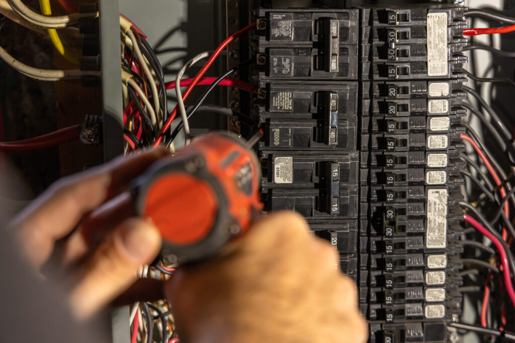 Electrician installing an electrical circuit breaker in a power panel